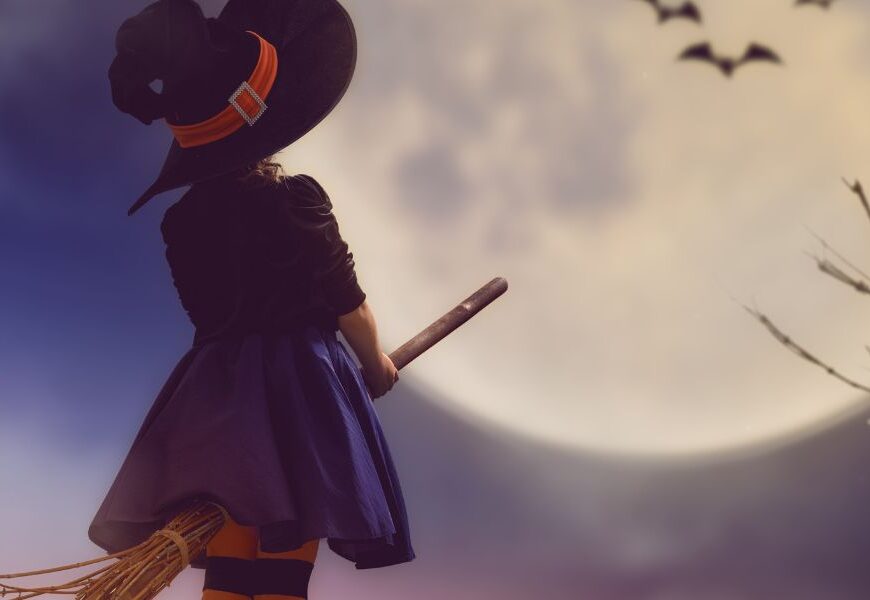girl dressed as witch on broomstick